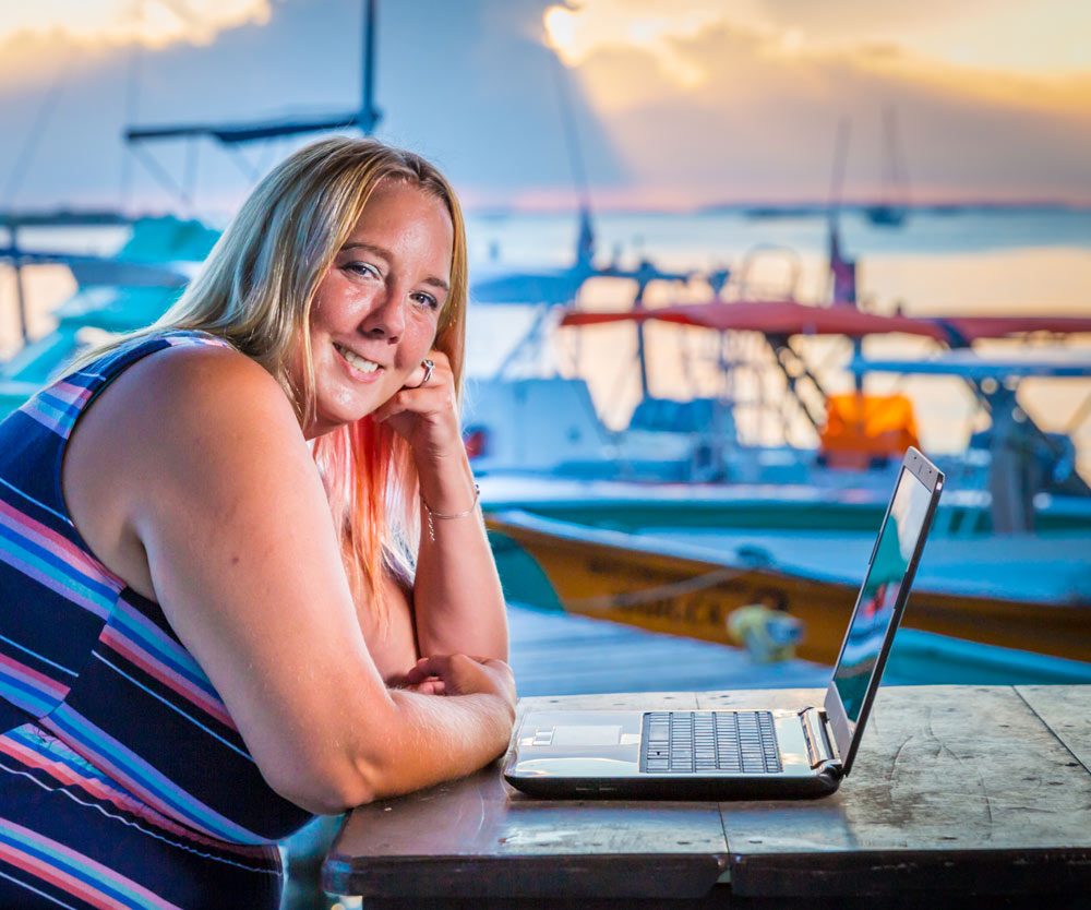 Keesha with laptop by boat docks